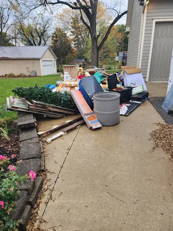 Dumpster being loaded with debris for 12 Yard Dumpster Rental in Franklin